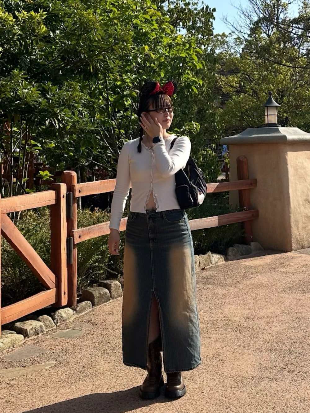 ホワイト系のTシャツ/カットソー、ブラック系のハンドバッグ、ブラウン系のブーツを着用したレディースの冬コーディネートの2枚目の写真