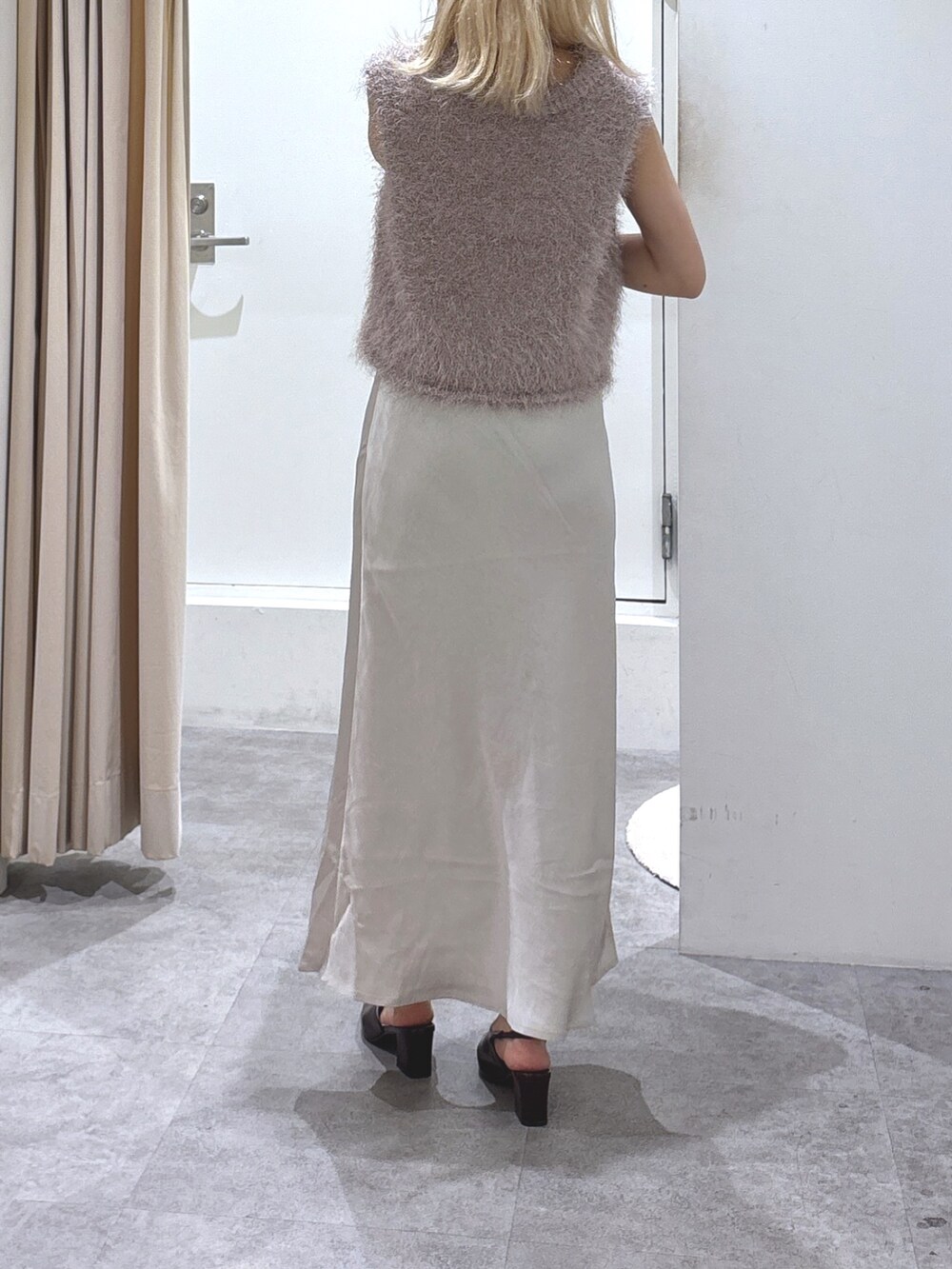 ベージュ系のニット/セーター、ホワイト系のスカートを着用したレディースの夏コーディネートの2枚目の写真