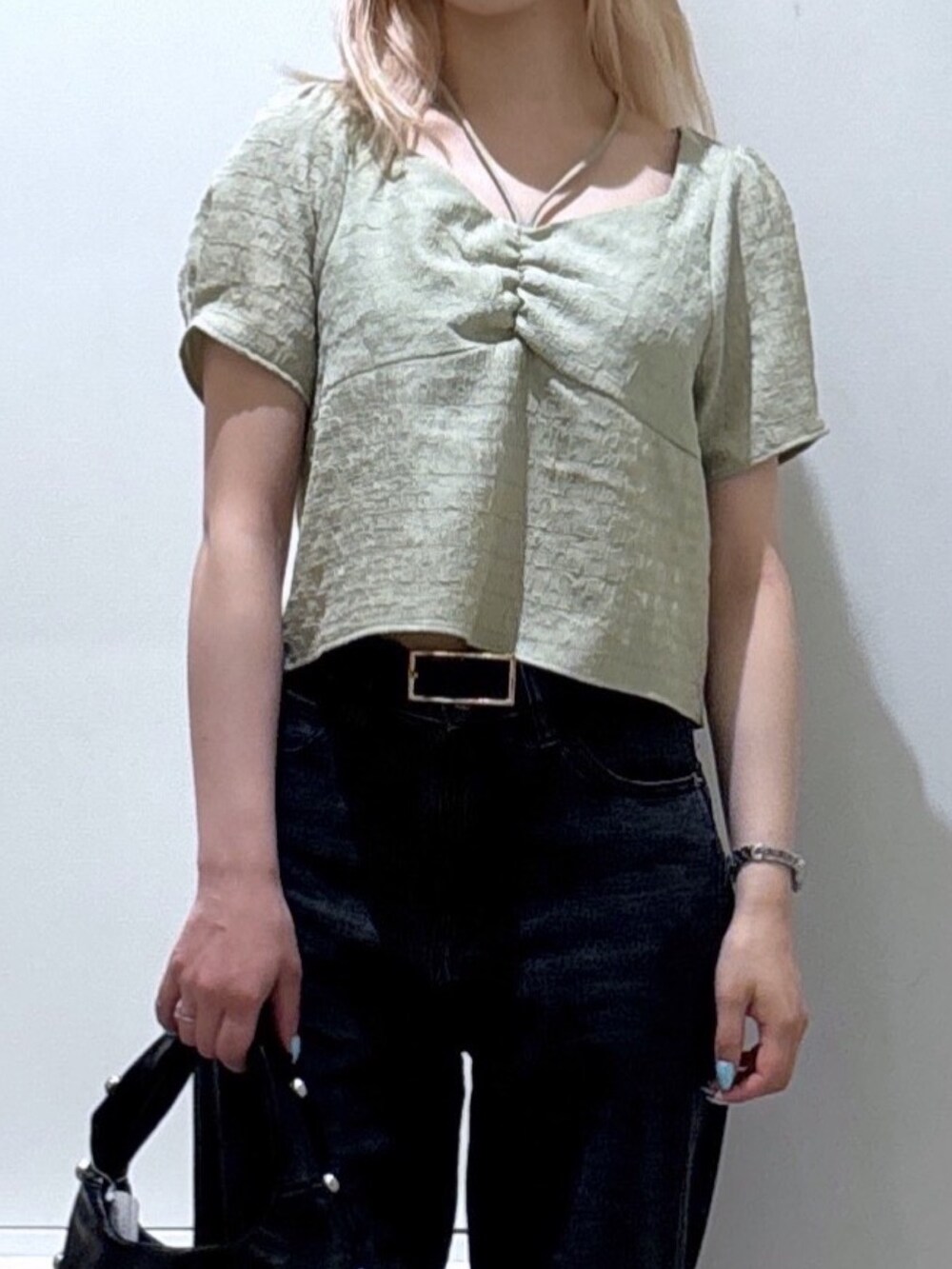 グリーン系のシャツ/ブラウス、ブラック系のデニムパンツ、ブラック系のハンドバッグを着用したレディースの夏コーディネートの2枚目の写真