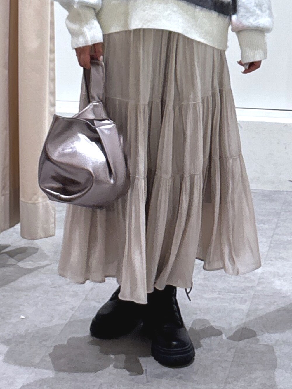 ホワイト系のニット/セーター、ホワイト系のスカート、ブラック系のブーツを着用したレディースの冬コーディネートの3枚目の写真