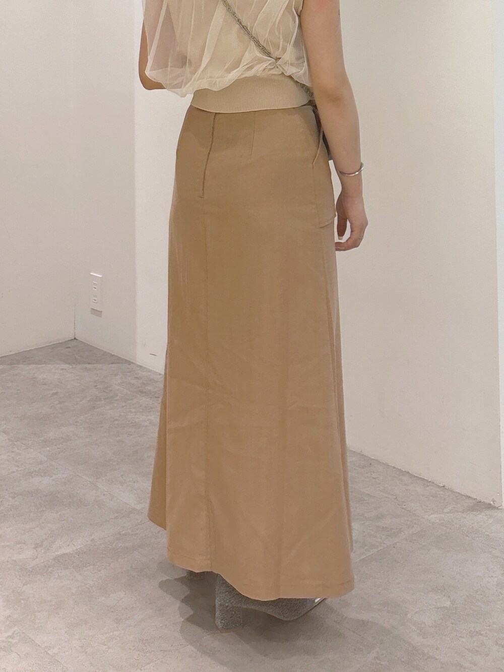 ホワイト系のベスト、ブラウン系のスカート、ブラック系のショルダーバッグを着用したレディースの夏コーディネートの4枚目の写真