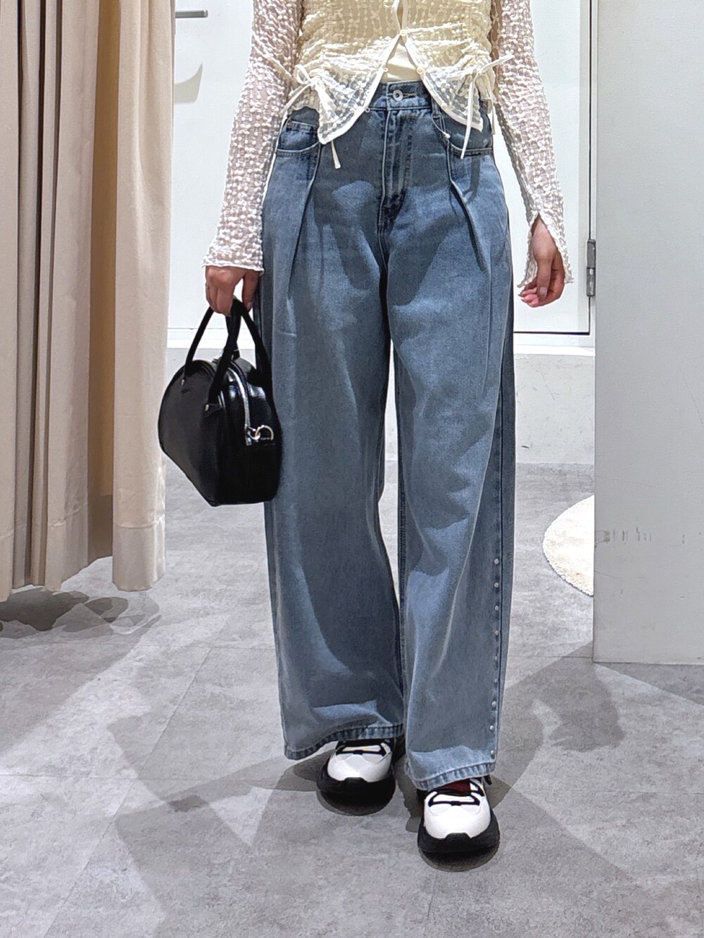 ホワイト系のカーディガン/ボレロ、ブルー系のデニムパンツ、ホワイト系のスニーカーを着用したレディースの春コーディネートの4枚目の写真