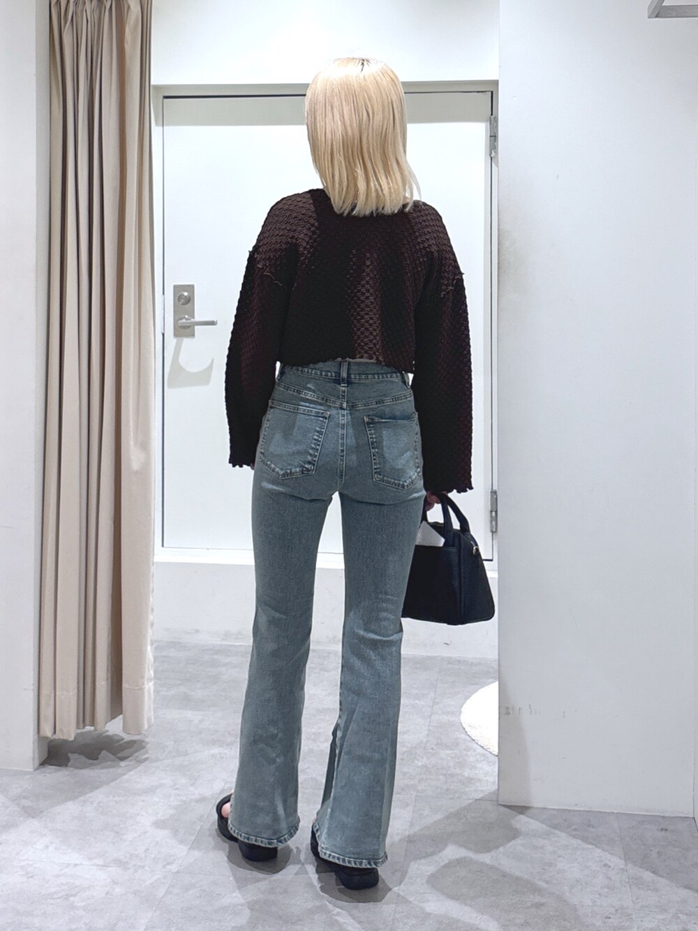 ブラウン系のカーディガン/ボレロ、ブルー系のデニムパンツ、グレー系のキャミソールを着用したレディースの春コーディネートの4枚目の写真