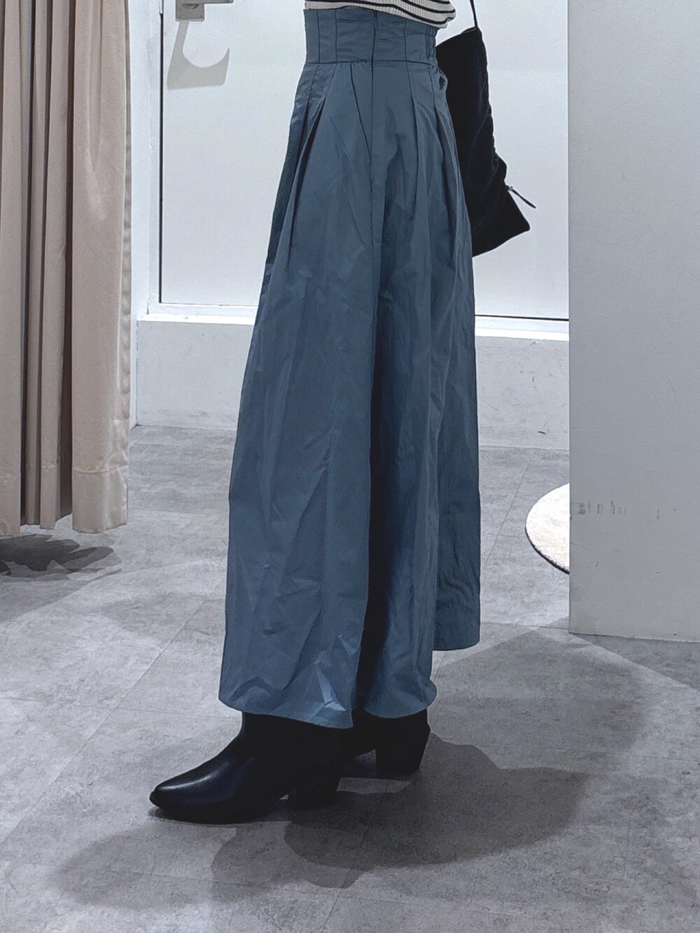 ホワイト系のニット/セーター、ブルー系のスカート、ブラック系のトートバッグを着用したレディースの冬コーディネートの2枚目の写真