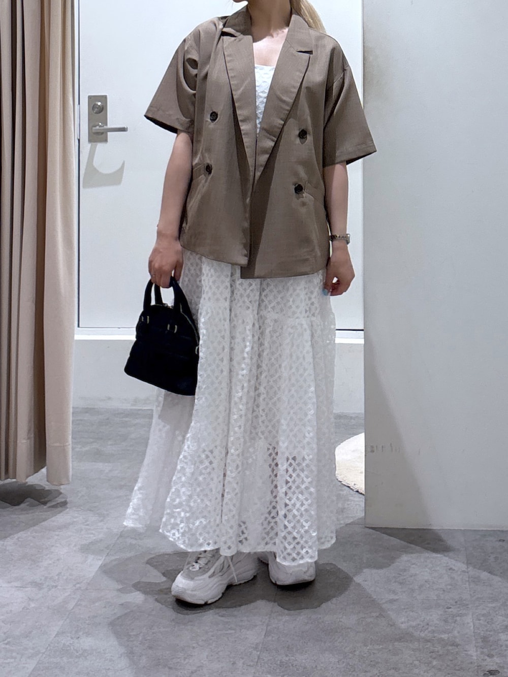 ホワイト系のワンピース、ブラウン系のテーラードジャケットを着用したレディースの夏コーディネートの3枚目の写真
