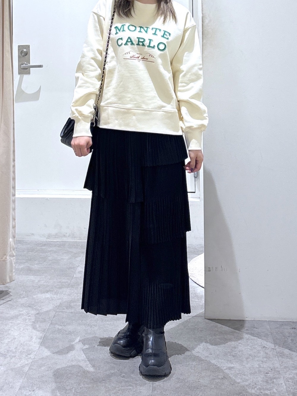 ホワイト系のスウェット、ブラック系のスカート、ブラック系のトートバッグを着用したレディースの冬コーディネートの2枚目の写真