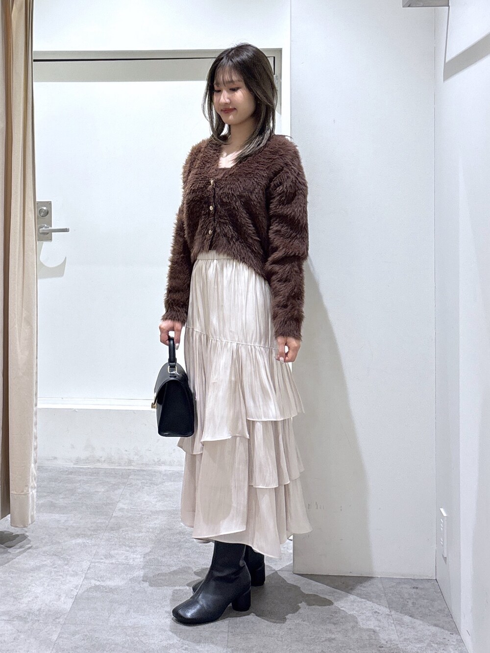 ブラウン系のニット/セーター、ブラック系のブーツ、ブラック系のトートバッグを着用したレディースの冬コーディネートの2枚目の写真