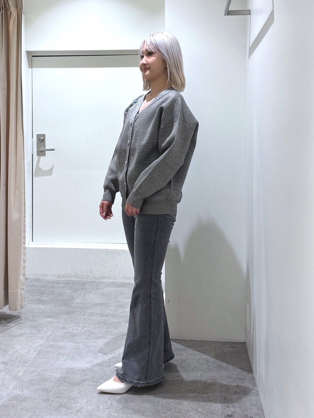 グレー系のカーディガン/ボレロ、ブラック系のデニムパンツ、ホワイト系のパンプスを着用したレディースの冬コーディネートの3枚目の写真