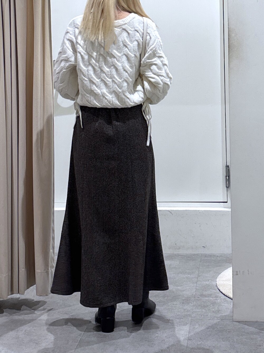 ホワイト系のニット/セーター、ブラウン系のスカートを着用したレディースの秋コーディネートの3枚目の写真
