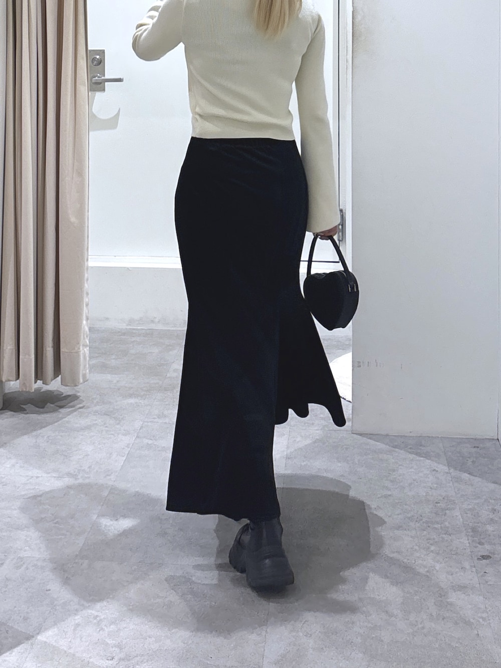 ホワイト系のニット/セーター、ブラック系のスカート、ブラック系のショルダーバッグを着用したレディースの冬コーディネートの3枚目の写真