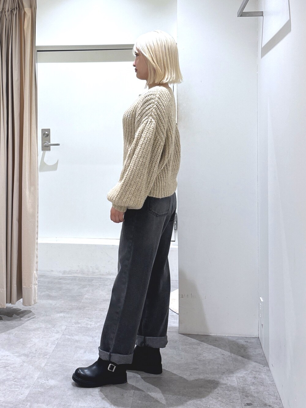 ベージュ系のニット/セーター、ブラック系のデニムパンツ、ブラック系のブーツを着用したレディースの冬コーディネートの3枚目の写真
