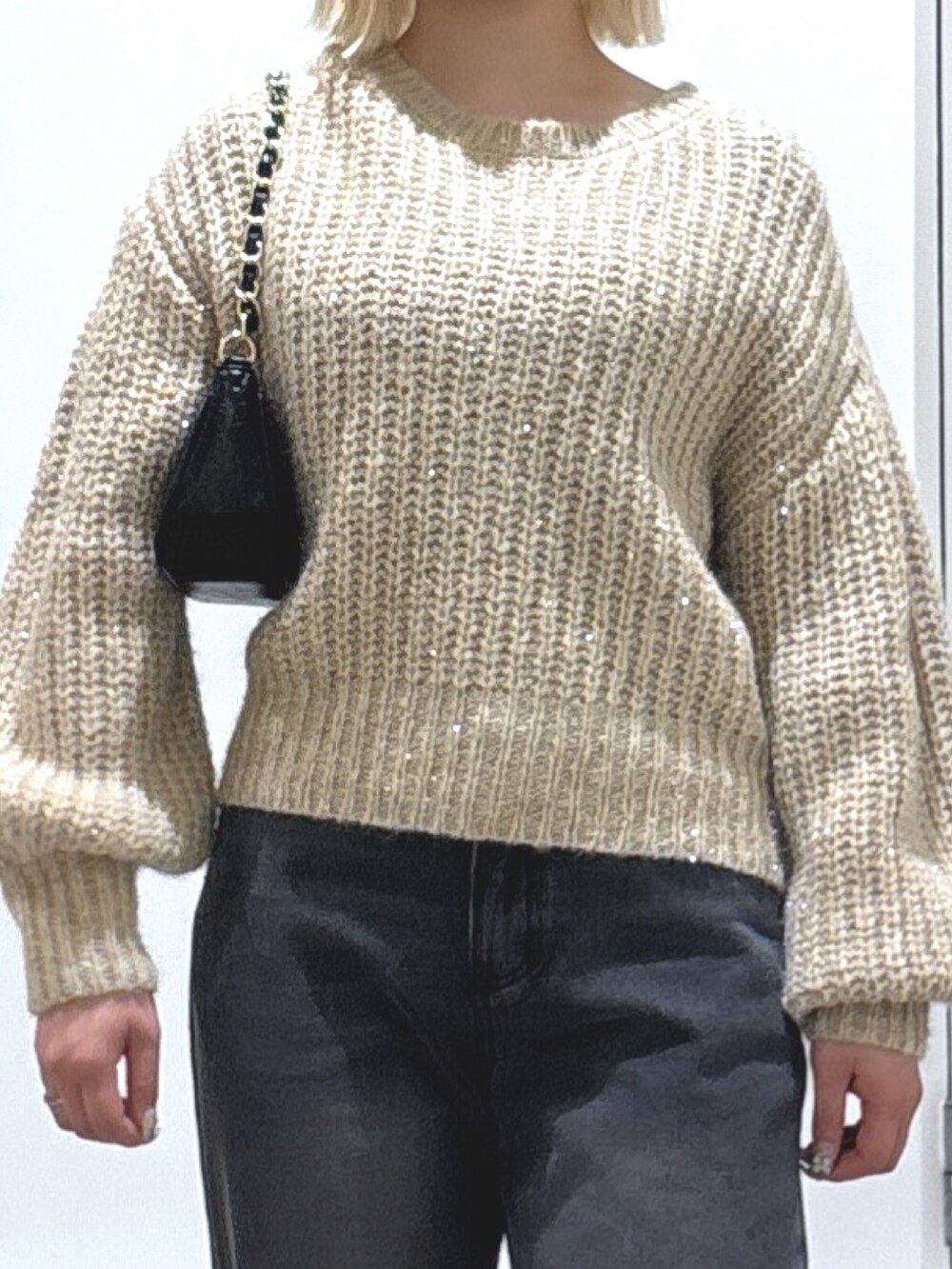 ベージュ系のニット/セーター、ブラック系のデニムパンツ、ブラック系のブーツを着用したレディースの冬コーディネートの2枚目の写真