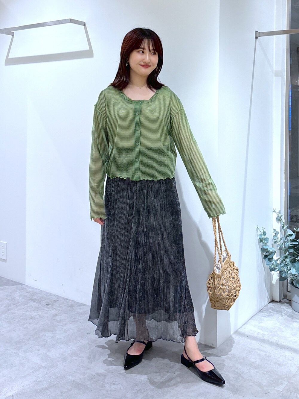 グレー系のカーディガン/ボレロ、ブラック系のスカート、ベージュ系のトートバッグを着用したレディースの夏コーディネートの2枚目の写真