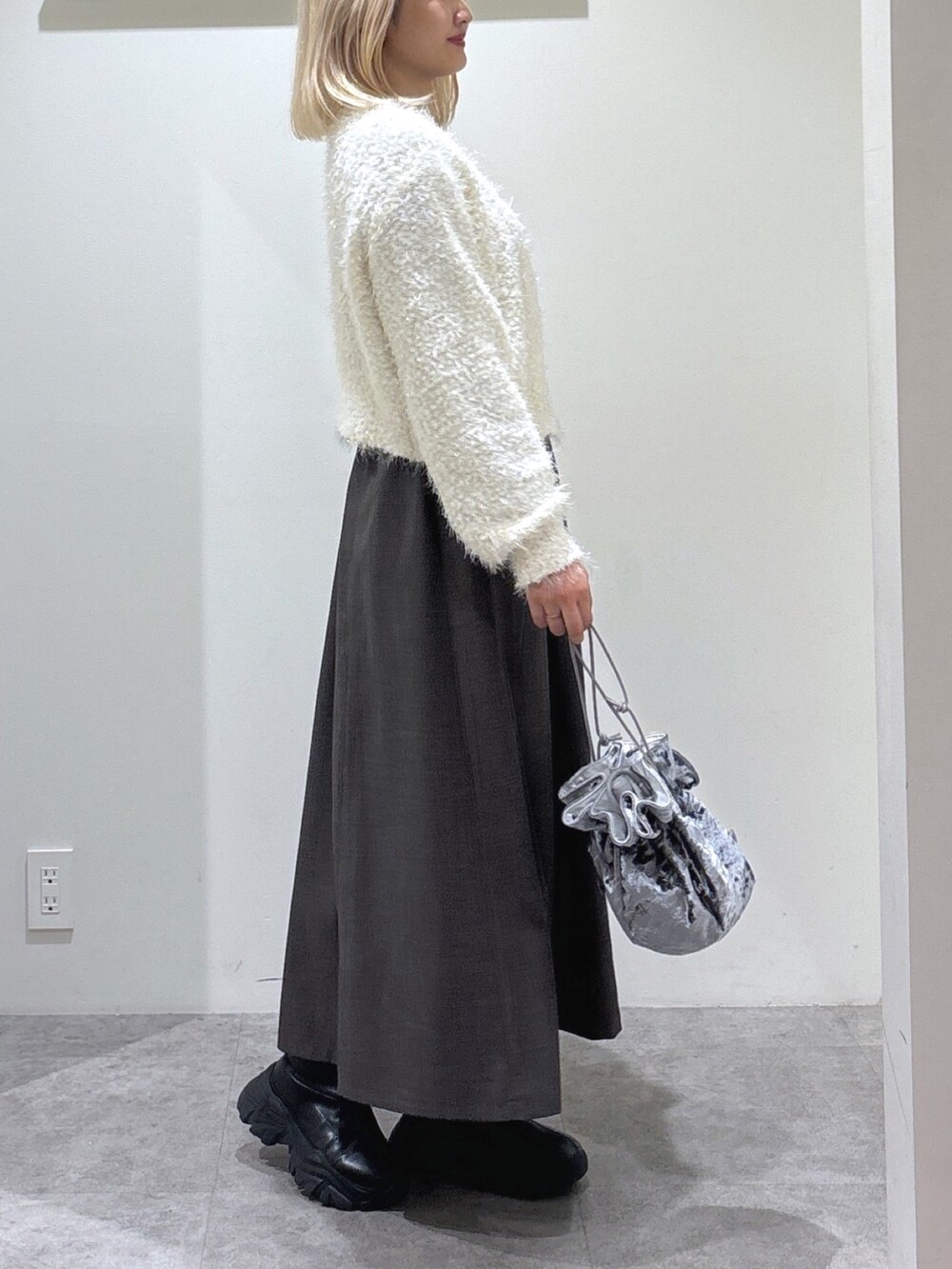 ブルー系のニット/セーター、ブラウン系のワンピース、グレー系のハンドバッグを着用したレディースの秋コーディネートの3枚目の写真