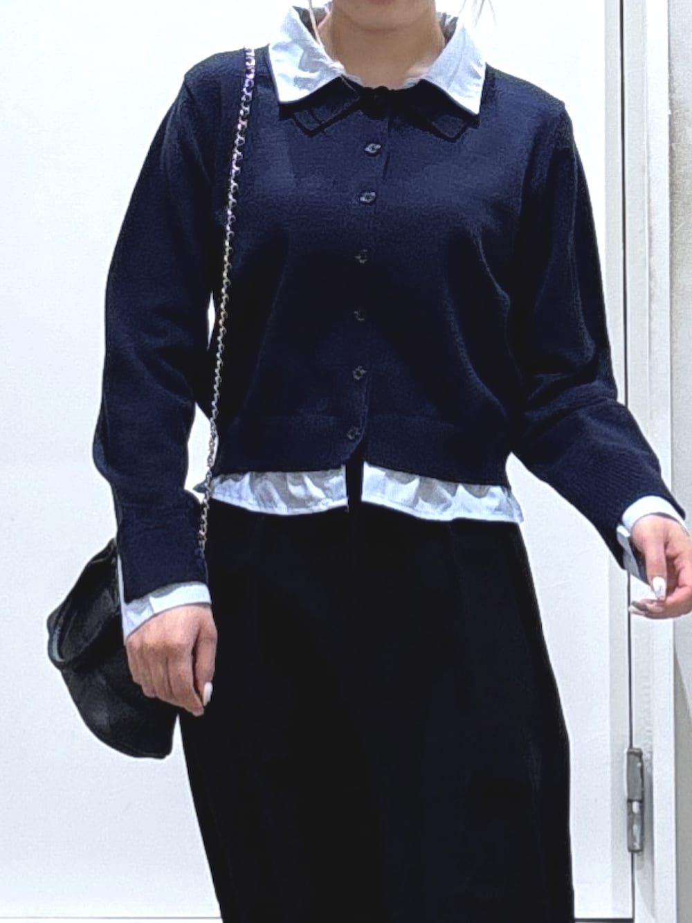 ブルー系のニット/セーター、ブラック系のスラックス、ブラック系のトートバッグを着用したレディースの冬コーディネートの2枚目の写真