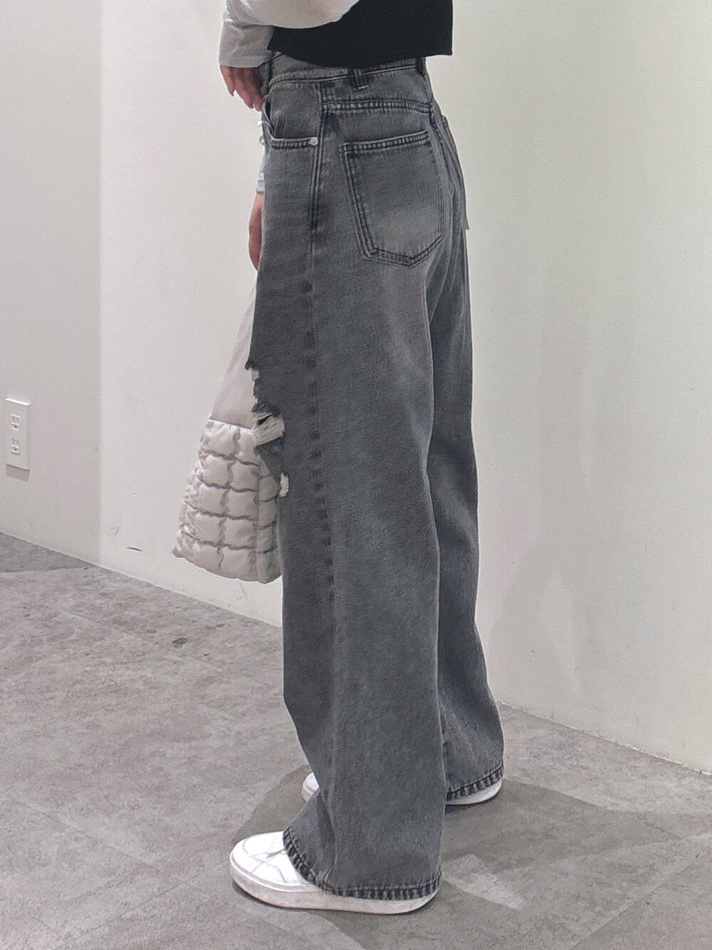 ブラック系のキャミソール、グレー系のTシャツ/カットソー、ブラック系のデニムパンツを着用したレディースの秋コーディネートの3枚目の写真