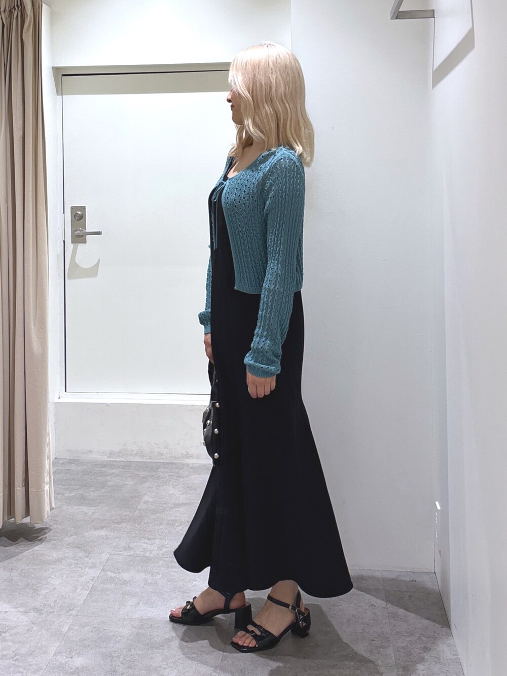 グリーン系のカーディガン/ボレロ、ブラック系のワンピース、ブラック系のサンダルを着用したレディースの夏コーディネートの3枚目の写真