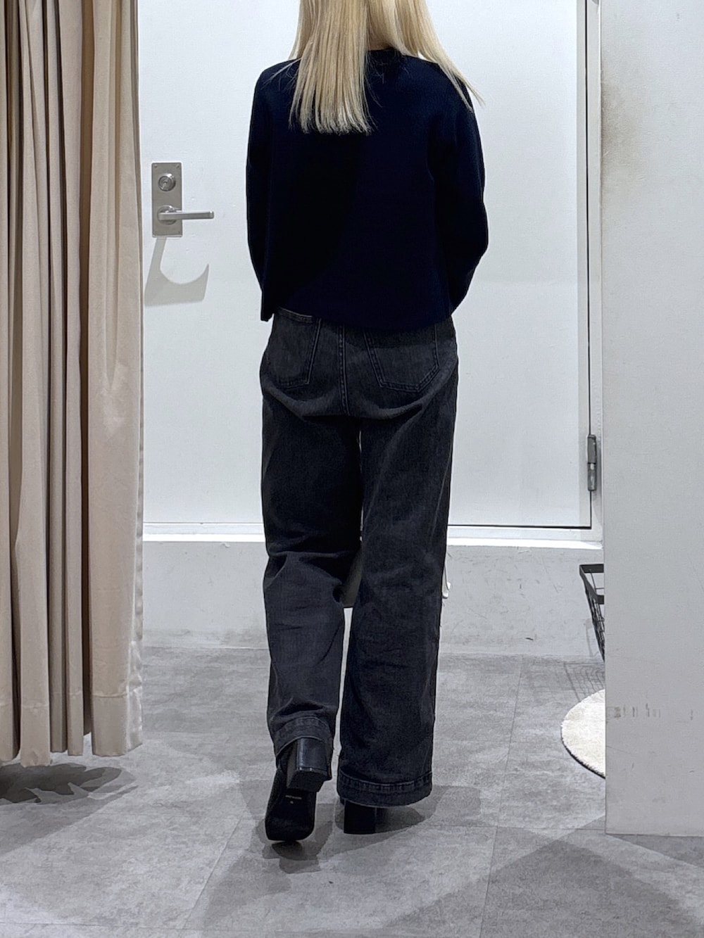 ブラック系のデニムパンツ、ブラック系のブーツを着用したレディースの秋コーディネートの2枚目の写真