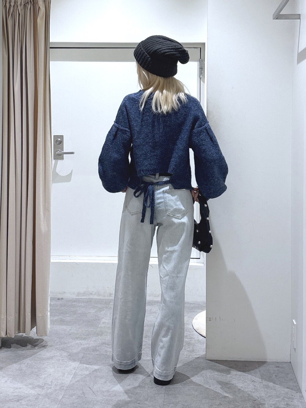 ブルー系のデニムパンツ、ブルー系のニット/セーターを着用したレディースの秋コーディネートの3枚目の写真