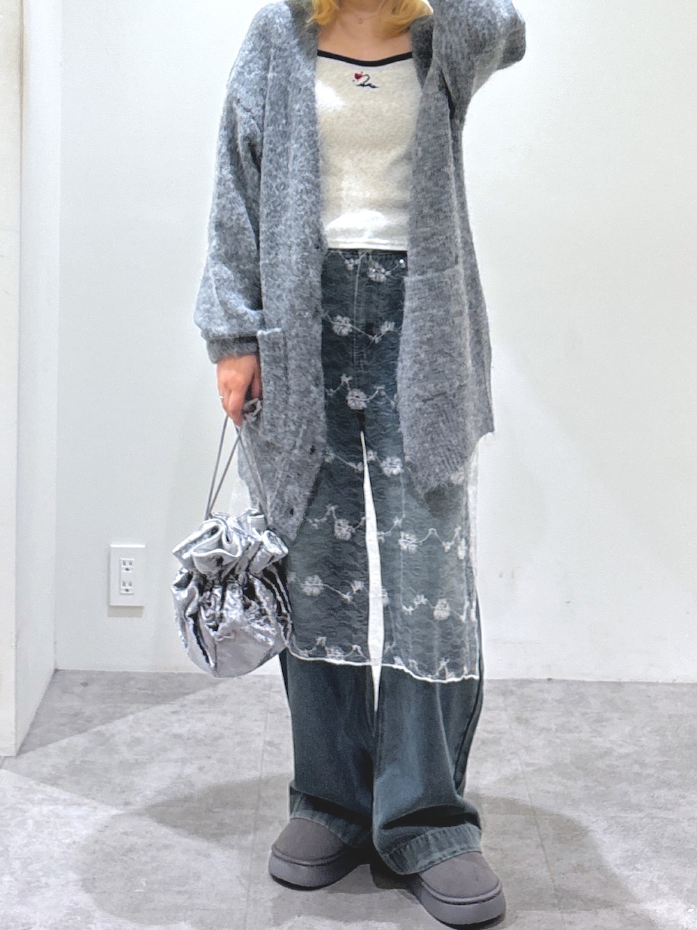 ブルー系のデニムパンツ、グレー系のブーツ、グレー系のハンドバッグを着用したレディースの秋コーディネートの3枚目の写真