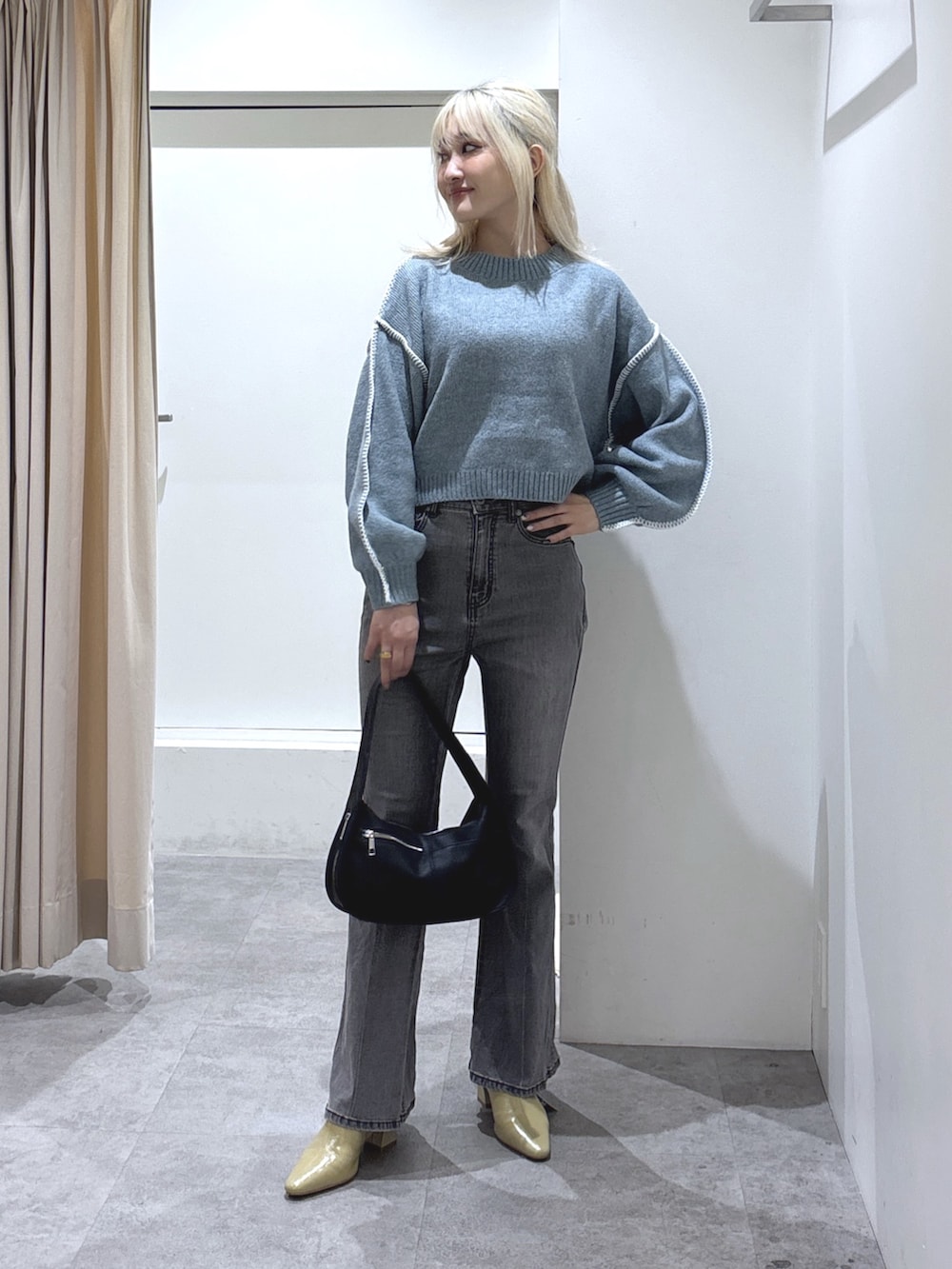 ブルー系のニット/セーター、ブラック系のデニムパンツを着用したレディースの秋コーディネートの2枚目の写真