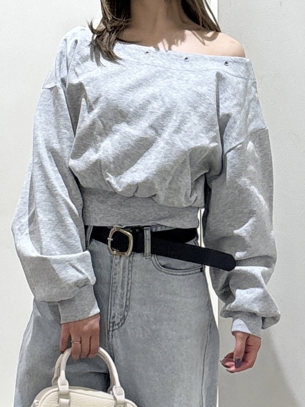 グレー系のスウェット、ブルー系のデニムパンツ、ブラウン系のブーツを着用したレディースの冬コーディネートの2枚目の写真