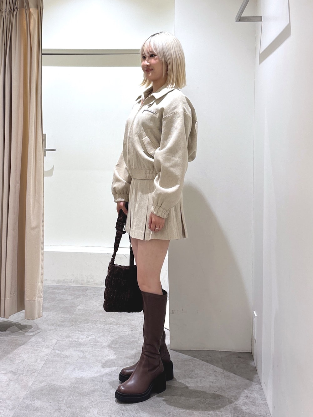 ベージュ系のその他アウター、ベージュ系のスカート、ブラウン系のショルダーバッグを着用したレディースの冬コーディネートの2枚目の写真