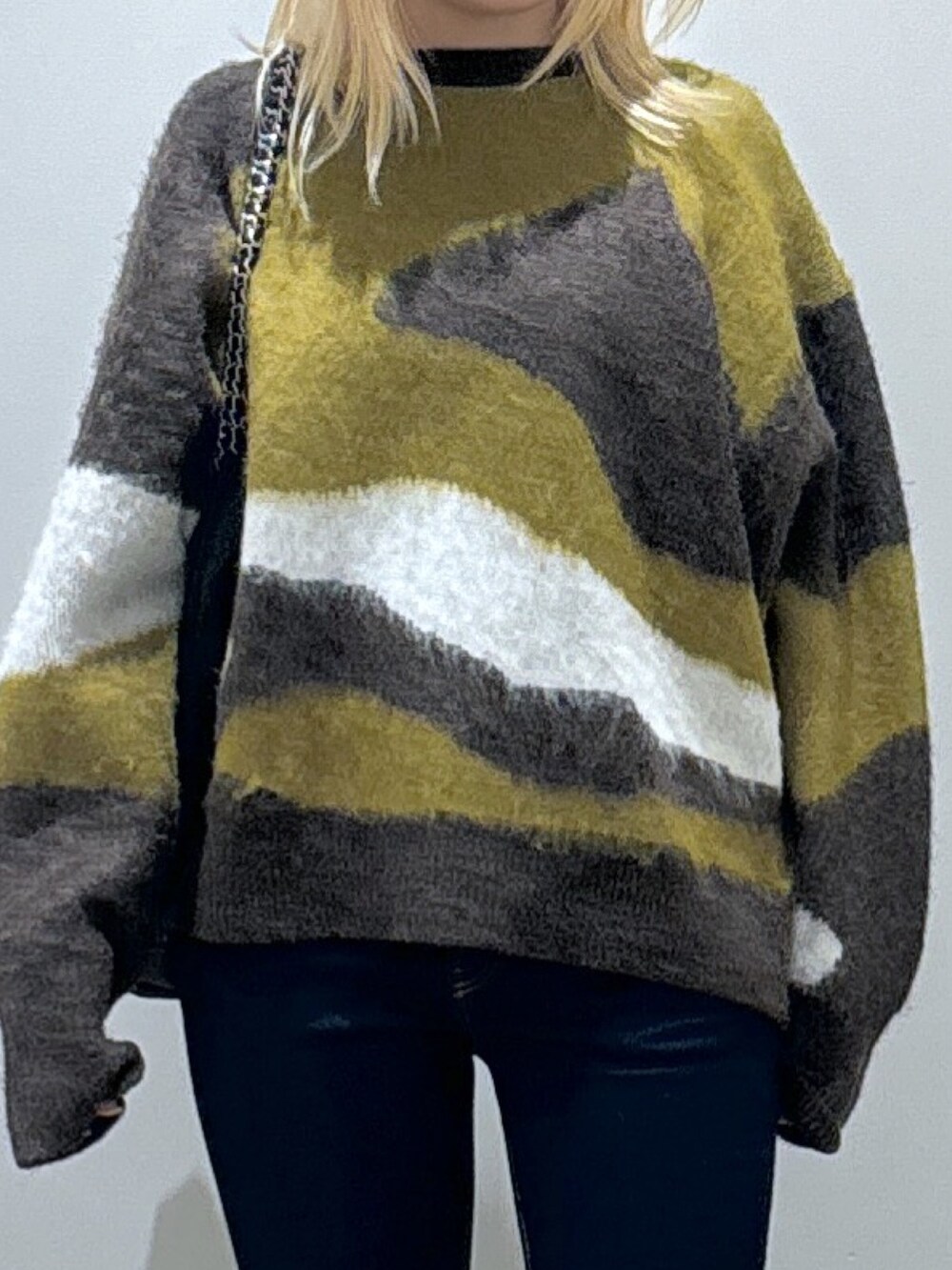 ブラウン系のニット/セーター、ブラック系のデニムパンツ、ブラック系のブーツを着用したレディースの秋コーディネートの2枚目の写真