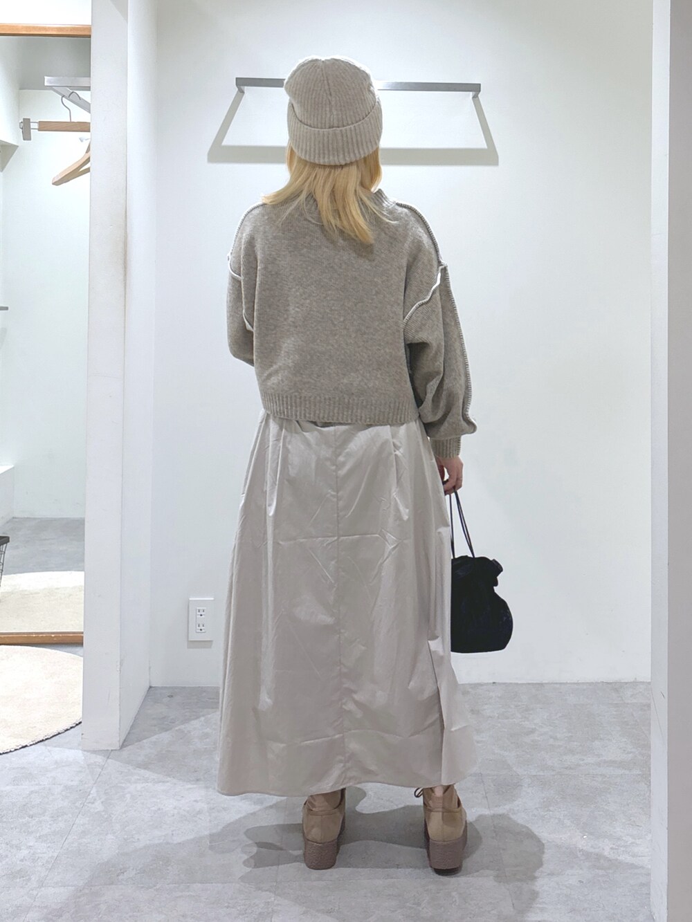 ベージュ系のニット/セーター、ベージュ系のスカート、ブラウン系のモカシン/デッキシューズを着用したレディースの秋コーディネートの4枚目の写真