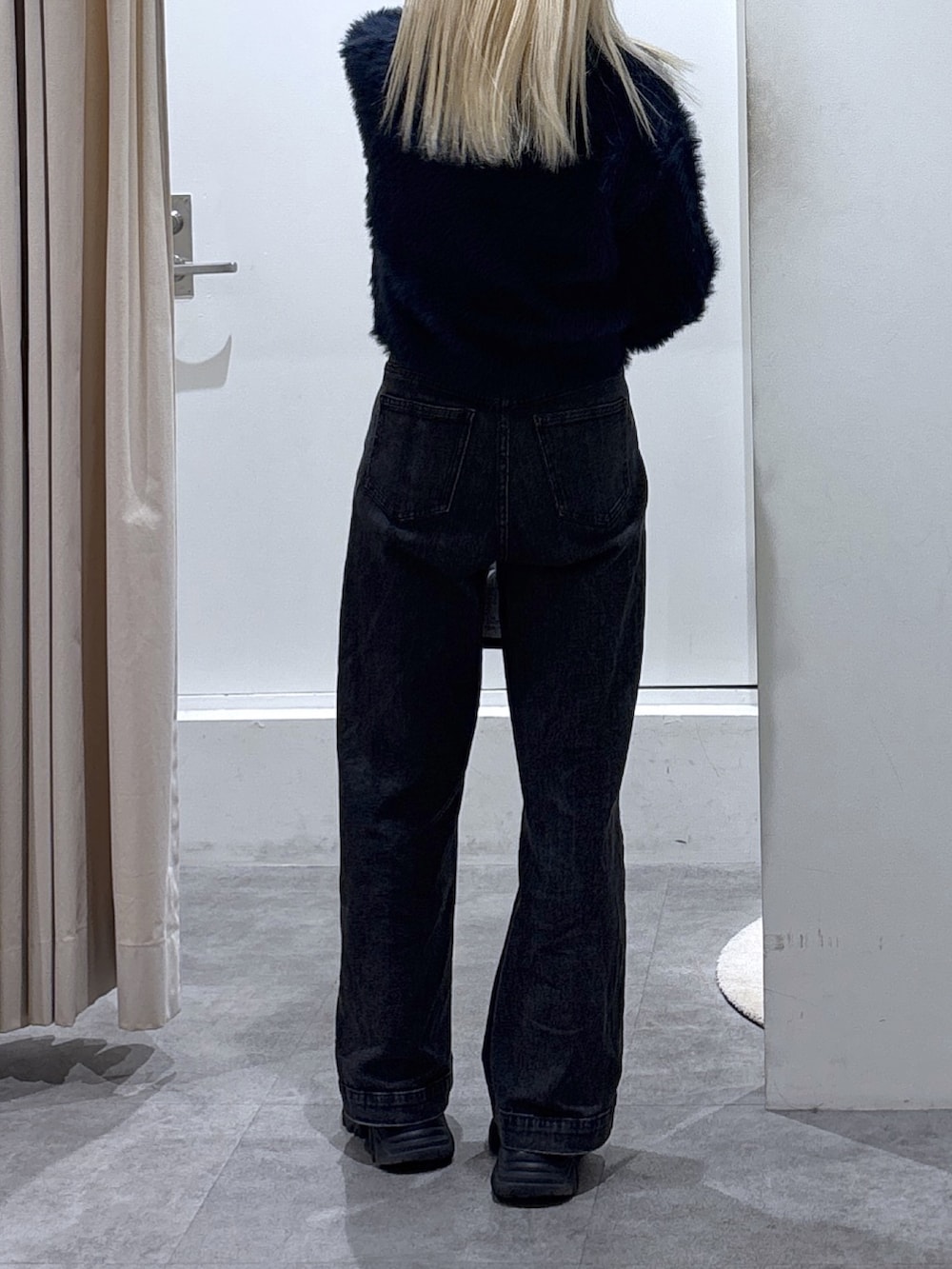 ブルー系のニット/セーター、ブラック系のデニムパンツを着用したレディースの秋コーディネートの3枚目の写真