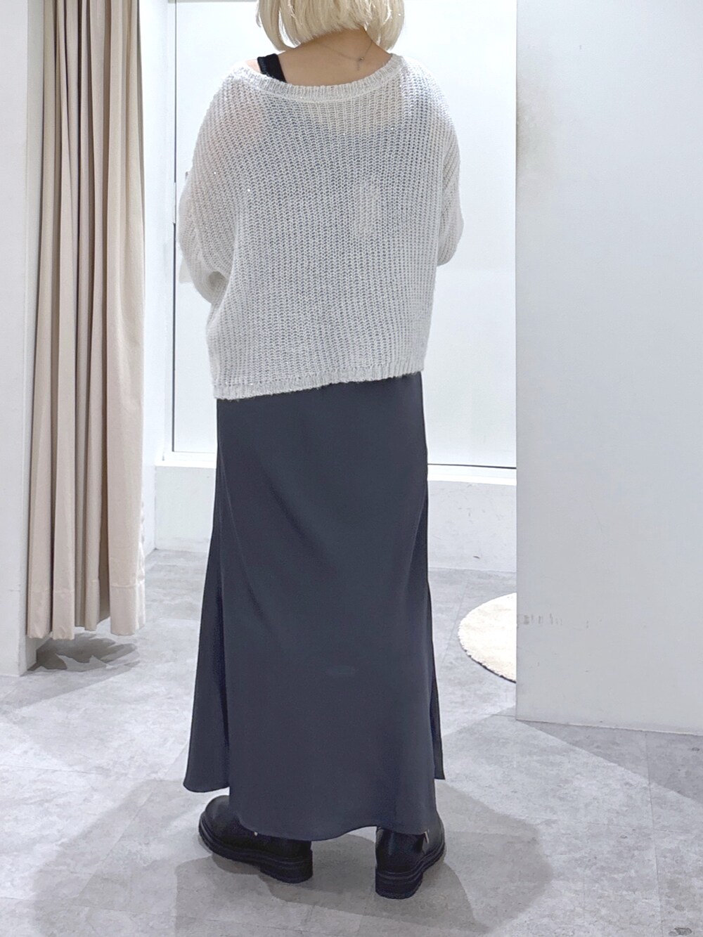 ホワイト系のニット/セーター、ブラック系のスカート、ブラック系のハンドバッグを着用したレディースの冬コーディネートの3枚目の写真