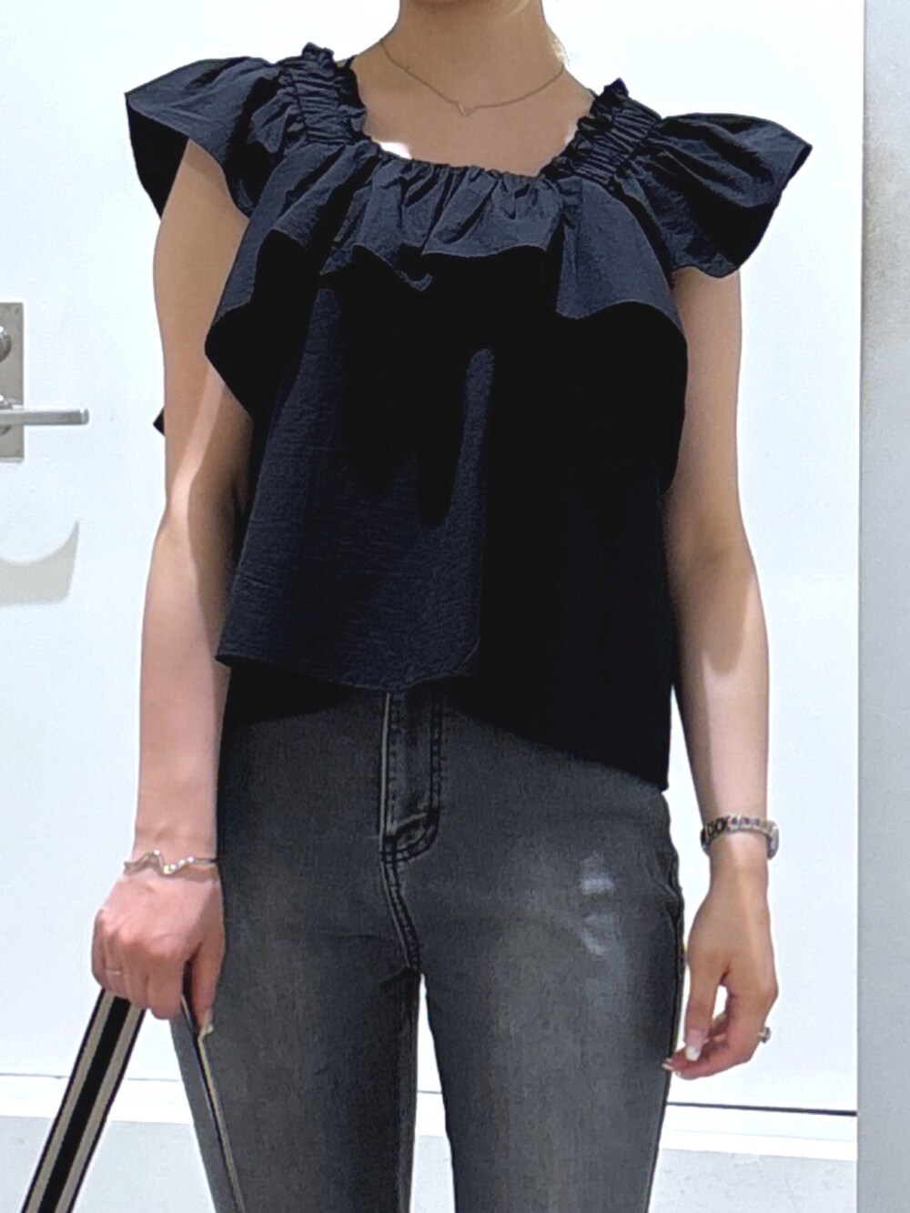 ブラック系のシャツ/ブラウス、ブラック系のデニムパンツを着用したレディースの春コーディネートの2枚目の写真