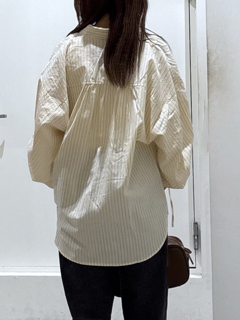 ホワイト系のシャツ/ブラウス、ブラック系のデニムパンツを着用したレディースの冬コーディネートの3枚目の写真