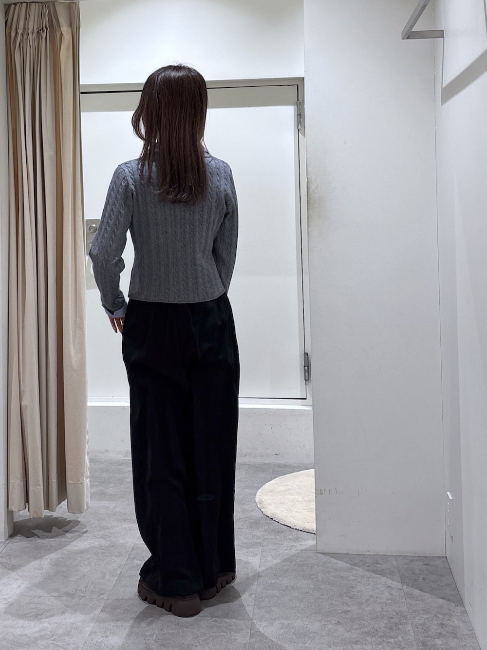 グレー系のニット/セーター、ブラック系のスラックスを着用したレディースの冬コーディネートの3枚目の写真