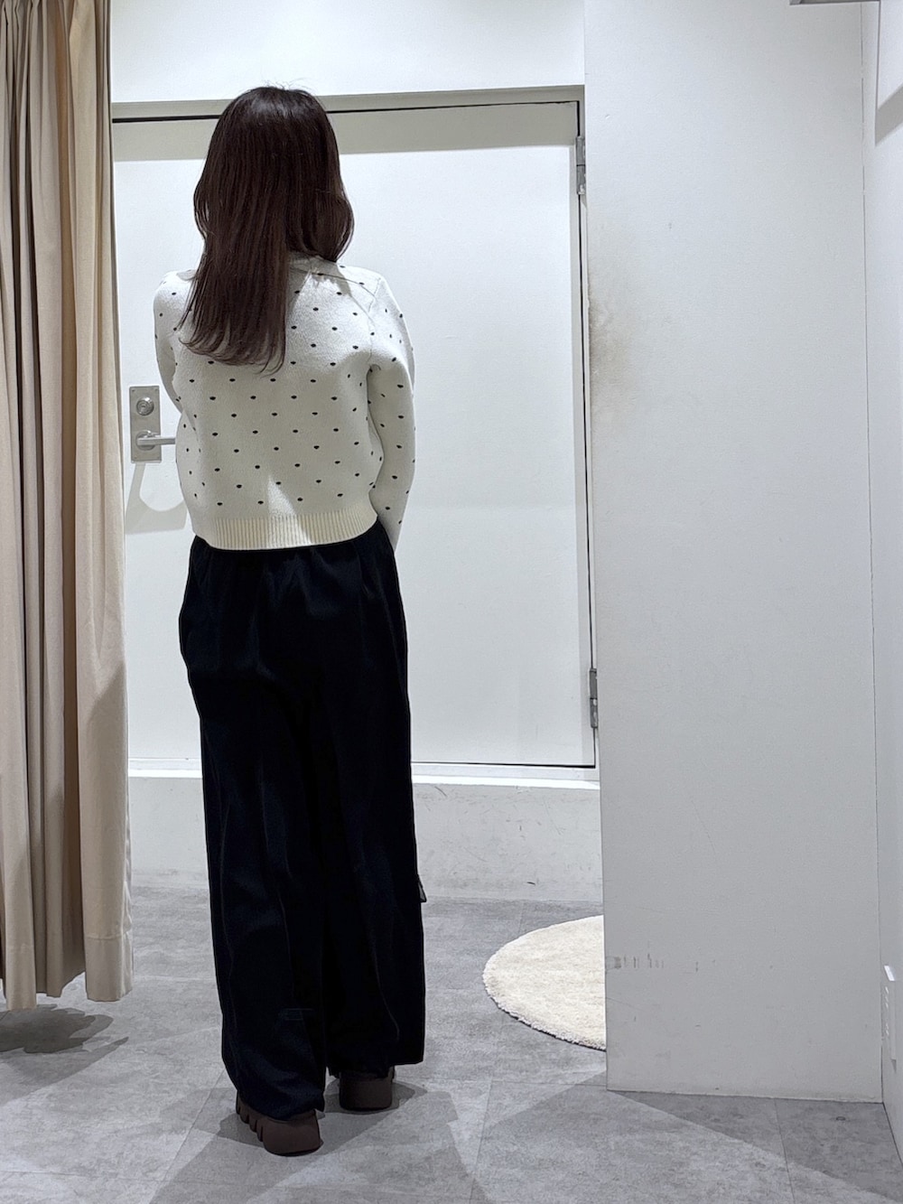 ホワイト系のニット/セーター、ブラック系のスラックスを着用したレディースの冬コーディネートの3枚目の写真