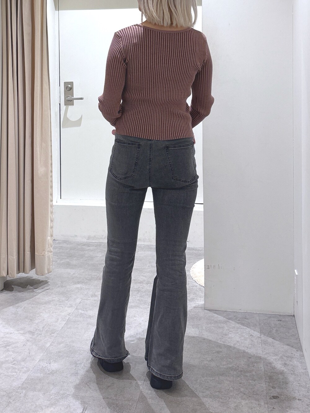 ピンク系のニット/セーター、ブラック系のデニムパンツ、ピンク系のショルダーバッグを着用したレディースの冬コーディネートの3枚目の写真