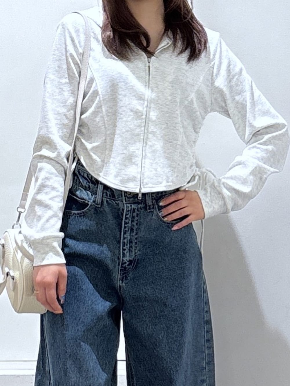 ホワイト系のパーカー、ブルー系のデニムパンツを着用したレディースの冬コーディネートの2枚目の写真