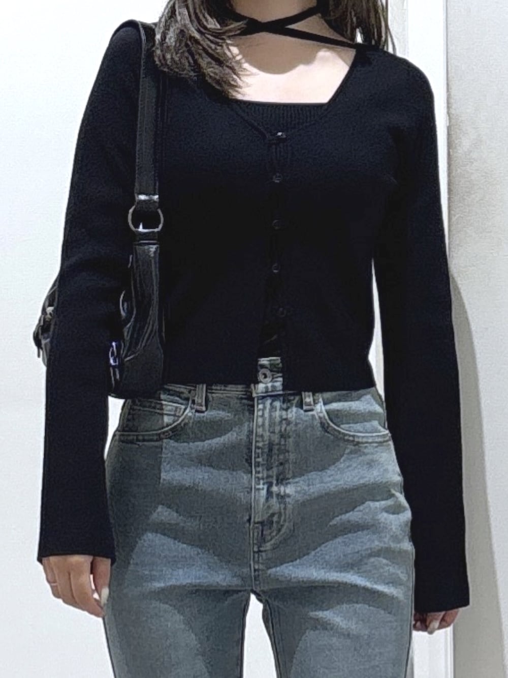 ブラック系のニット/セーター、ブルー系のデニムパンツ、ブラック系のブーツを着用したレディースの冬コーディネートの2枚目の写真