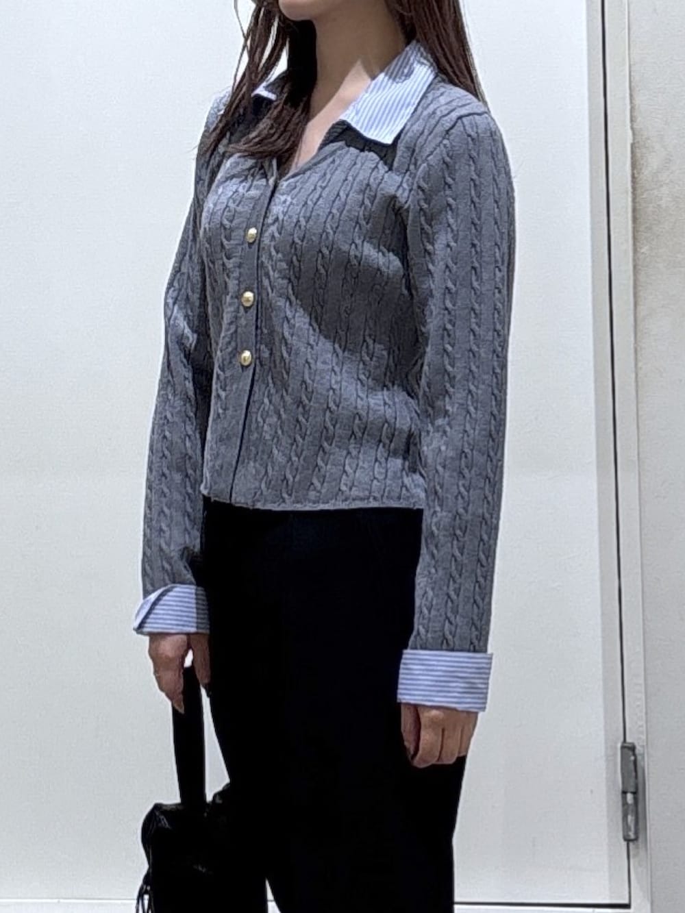 グレー系のニット/セーター、ブラック系のスラックスを着用したレディースの冬コーディネートの2枚目の写真