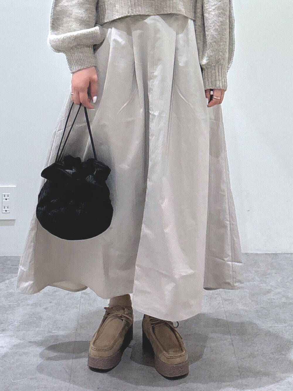 ベージュ系のニット/セーター、ベージュ系のスカート、ブラウン系のモカシン/デッキシューズを着用したレディースの秋コーディネートの3枚目の写真