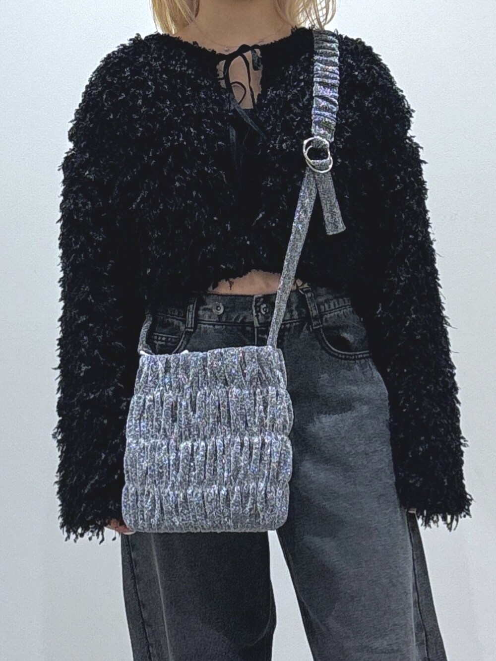 ブラック系のカーディガン/ボレロ、ブラック系のデニムパンツ、シルバー系のショルダーバッグを着用したレディースの秋コーディネートの2枚目の写真