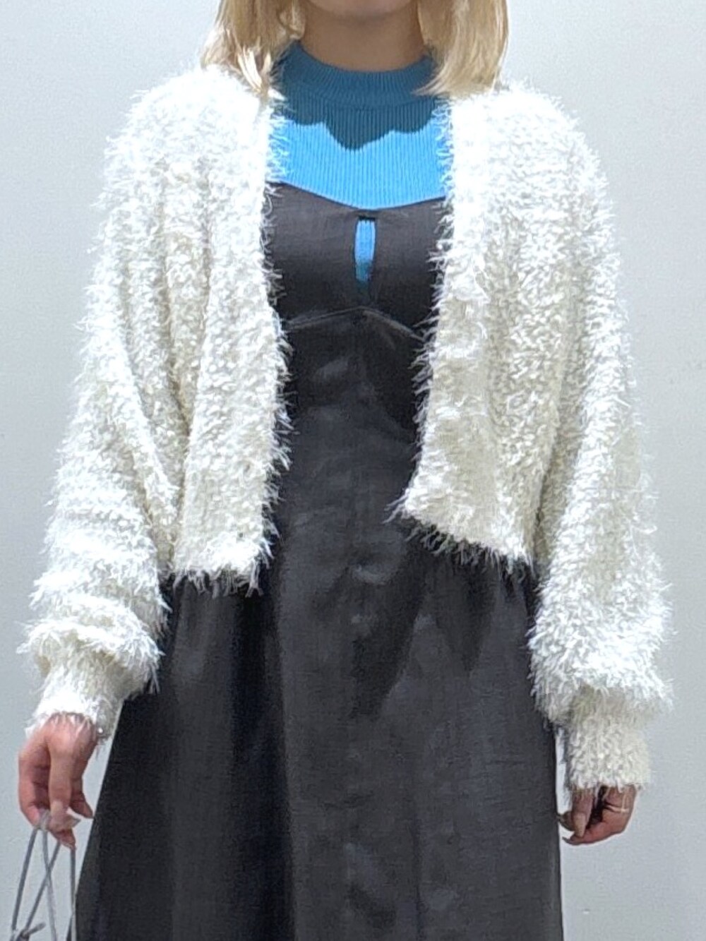 ブルー系のニット/セーター、ブラウン系のワンピース、グレー系のハンドバッグを着用したレディースの秋コーディネートの2枚目の写真