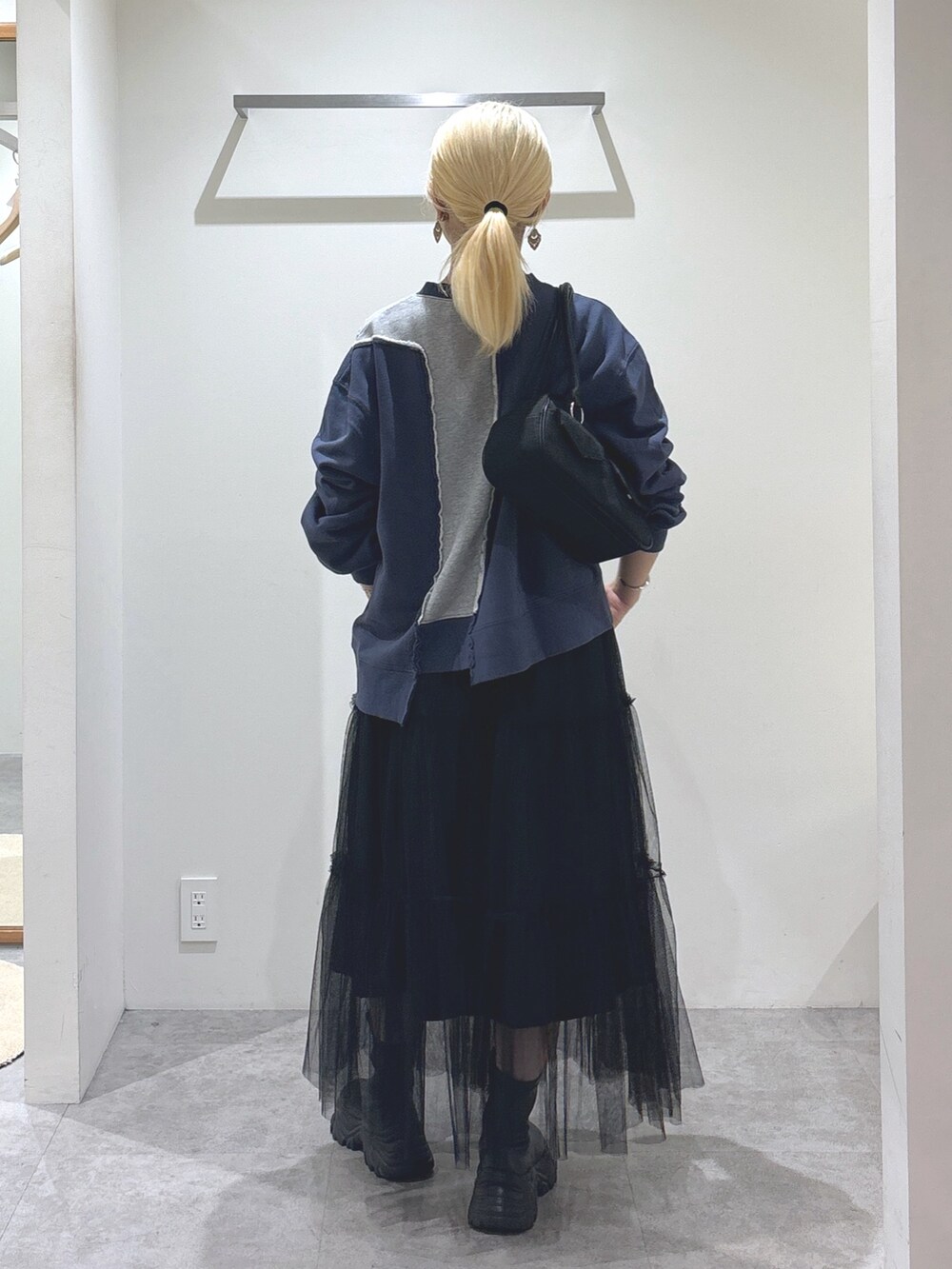 ブルー系のスウェット、ブラック系のスカート、ブラック系のトートバッグを着用したレディースの秋コーディネートの3枚目の写真