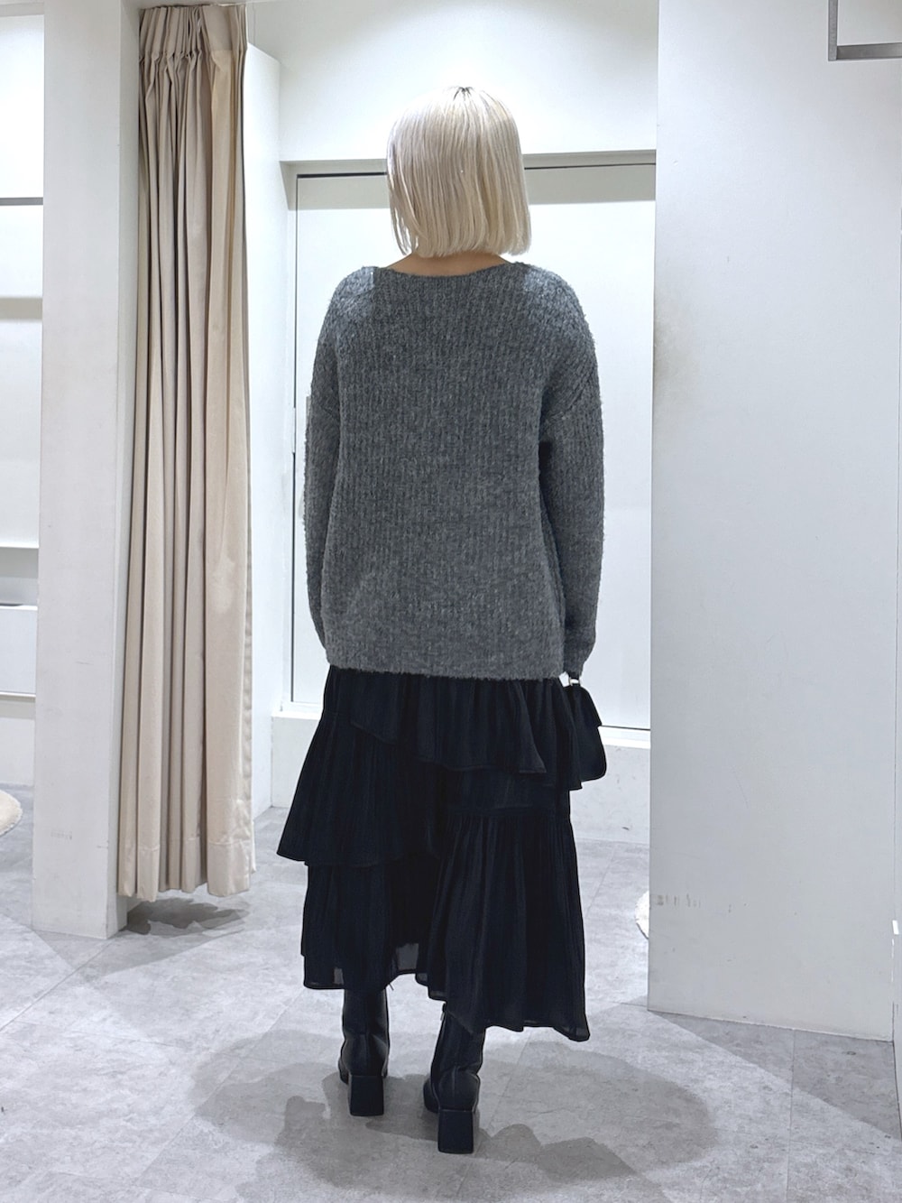 グレー系のニット/セーター、ブラック系のショルダーバッグ、ブラック系のスカートを着用したレディースの冬コーディネートの4枚目の写真