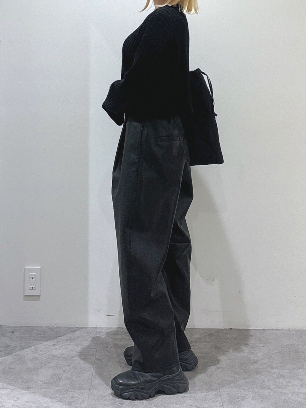 ブラック系のニット/セーター、ブラック系のその他パンツ、ブラック系のトートバッグを着用したレディースの秋コーディネートの3枚目の写真