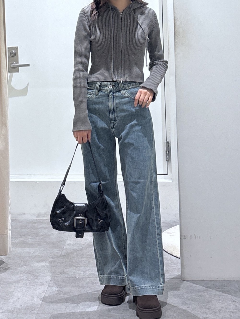 グレー系のパーカー、ブルー系のデニムパンツを着用したレディースの冬コーディネートの3枚目の写真