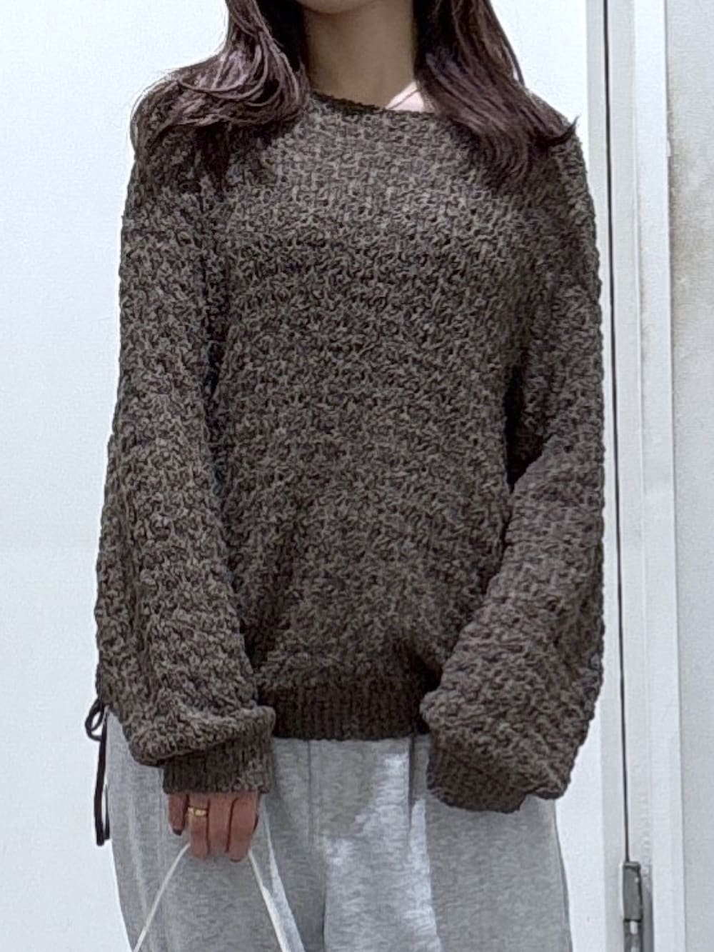 ブラウン系のニット/セーター、グレー系のその他パンツを着用したレディースの冬コーディネートの2枚目の写真