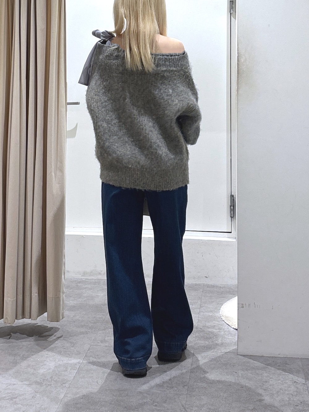 グレー系のニット/セーター、ブルー系のデニムパンツを着用したレディースの冬コーディネートの4枚目の写真