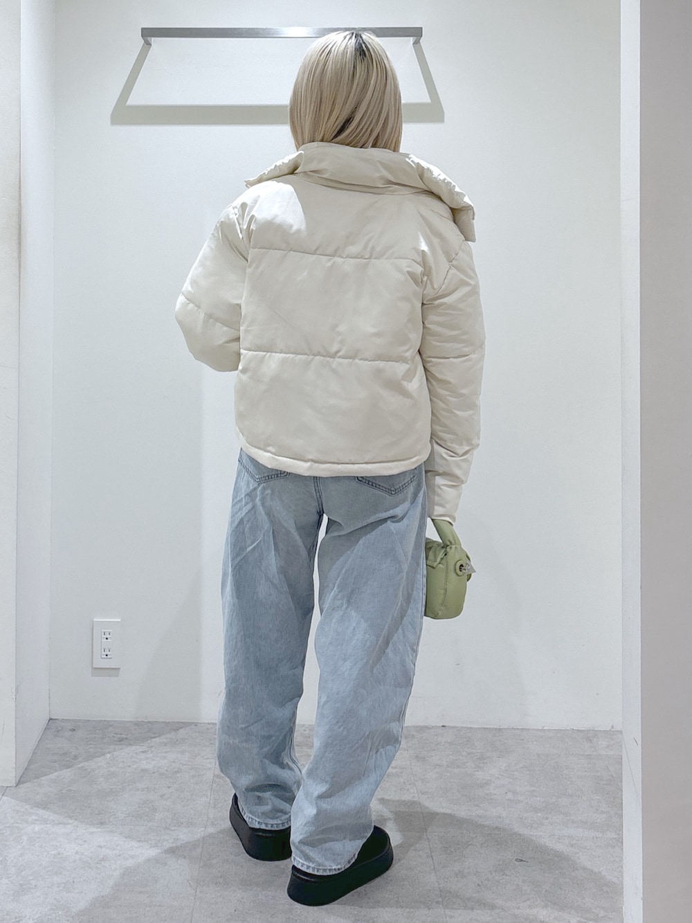ホワイト系のブルゾン、ブルー系のデニムパンツ、ホワイト系のスウェットを着用したレディースの秋コーディネートの3枚目の写真