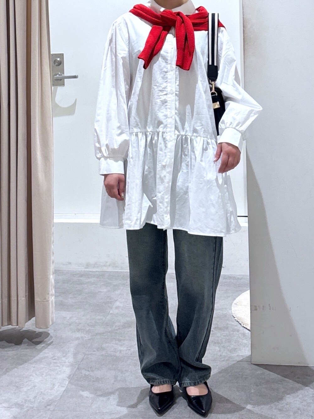 ブルー系のデニムパンツ、レッド系のカーディガン/ボレロ、ホワイト系のワンピースを着用したレディースの春コーディネートの3枚目の写真